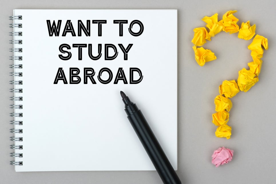 Hand with marker writing: Want to Study Abroad.